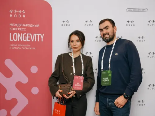 Двое участников с бейджами у брендированного пресс-волла конгресса